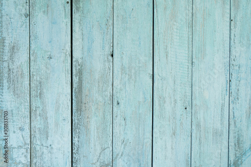 old wooden fence light blue paint peeling board texture. Background