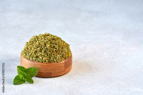 Fototapeta Naklejka Na Ścianę i Meble -  Mixed spice zaatar or zatar in wooden bowl on stone background