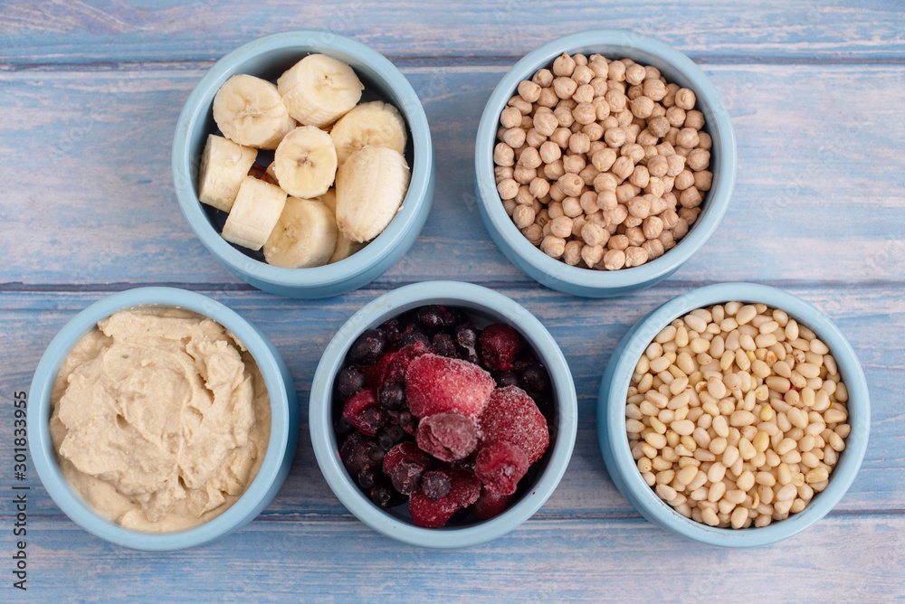 ingredients for making smoothies in bowls - frozen berries, banana, hummus, chickpea and pine nuts ingredients for making smoothies in bowls - frozen berries, banana, hummus, chickpea and pine nuts