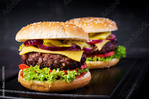 Big sandwich - hamburger burger with beef,  tomato, cheese, pickled cucumber and red onion.