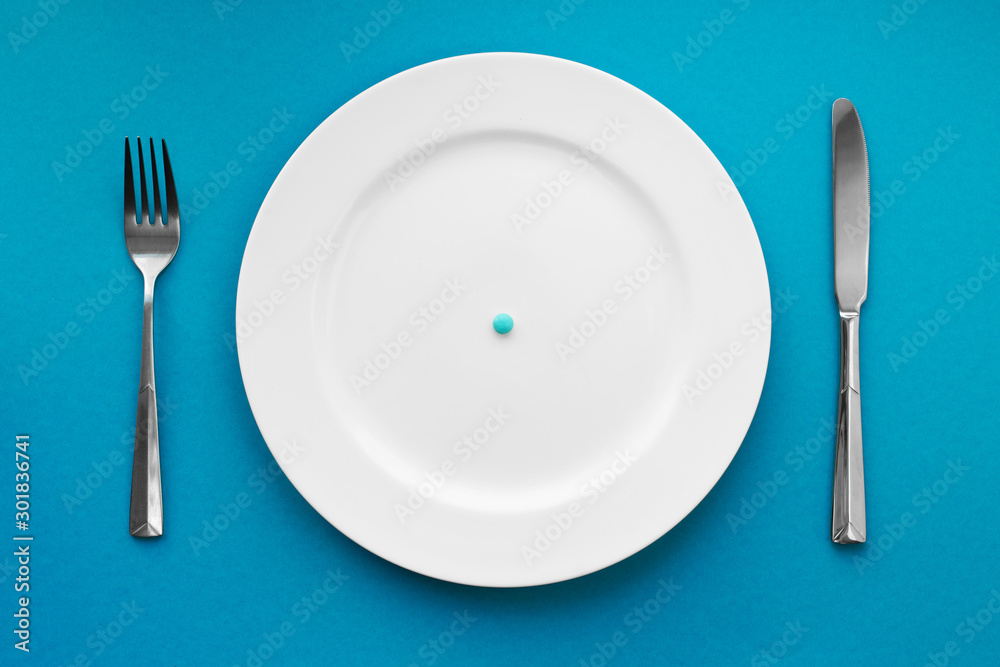 A small tablet in a plate. Medical concept. Eat pills instead of food. A small tablet in a plate. Medical concept. Eat pills instead of food.