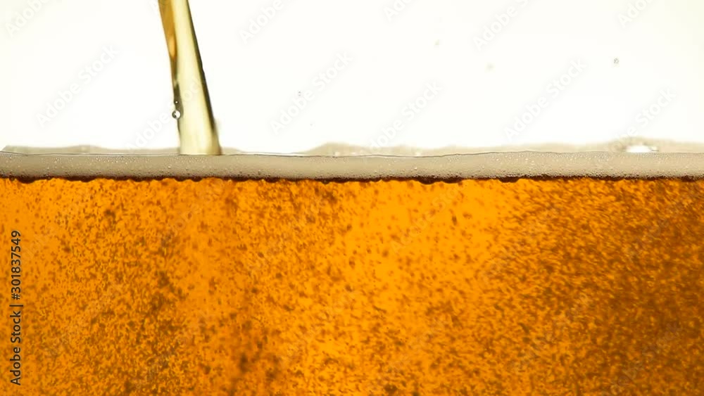 Close up pouring beer with bubbles in glass