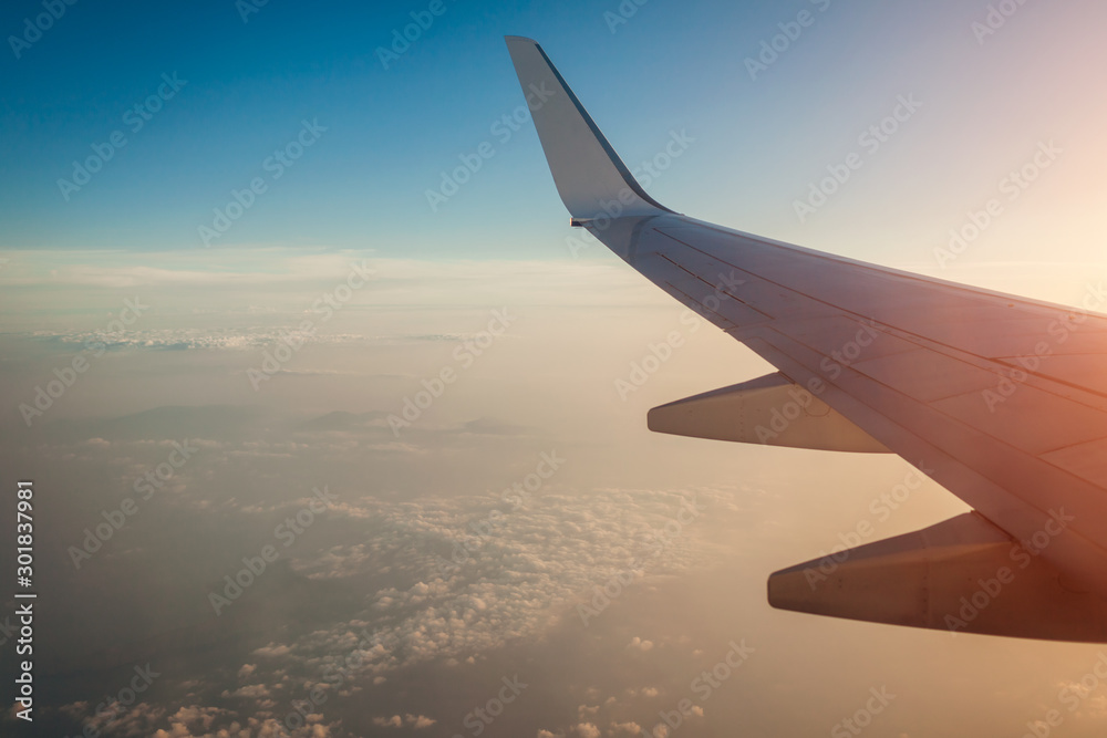 Plane window view of clouds and islands surrounded by sea and airplane wing. Traveling concept Plane window view of clouds and islands surrounded by sea and airplane wing. Traveling concept