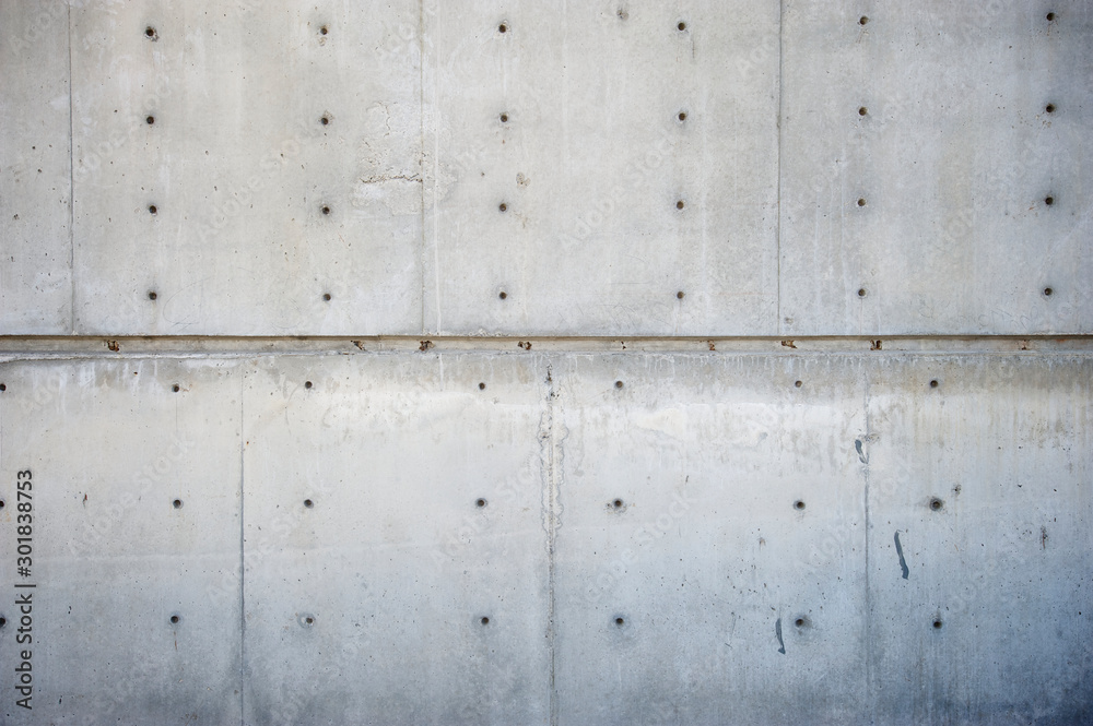 Fresh new concrete wall background with raw construction formwork lines and tie hole plugs Fresh new concrete wall background with raw construction formwork lines and tie hole plugs