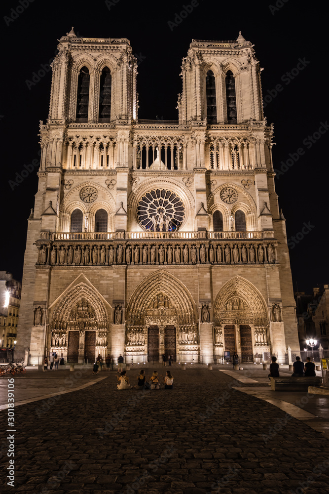 A west facade of the Notre-Dame-de-Paris Cathedral illuminated in the night