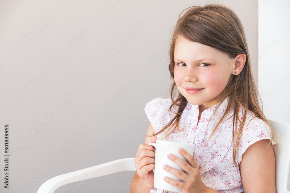 Portrait of smiling little girl with white cup of hot drink Portrait of smiling little girl with white cup of hot drink