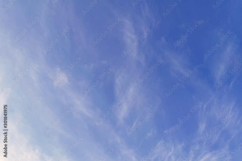 Bright blue autumn sky with light white clouds.