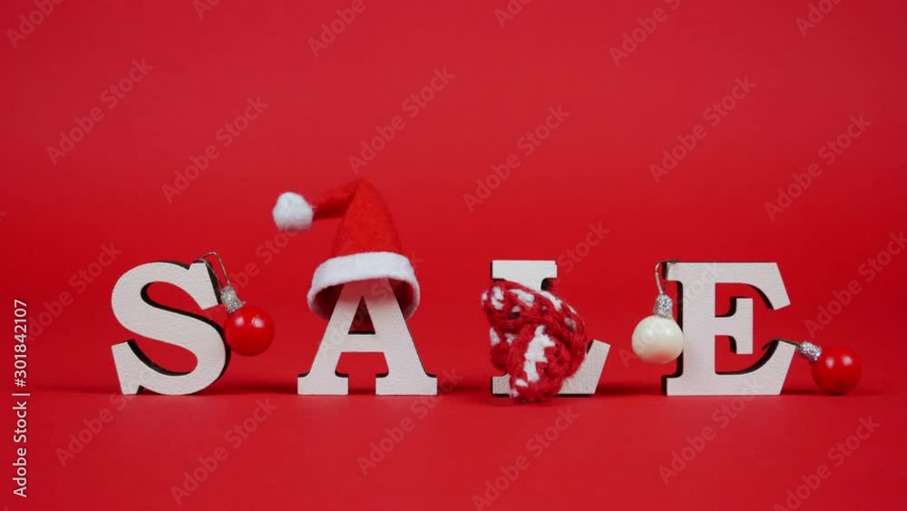White letters form word sale on red background. Cute christmas elements on the inscription