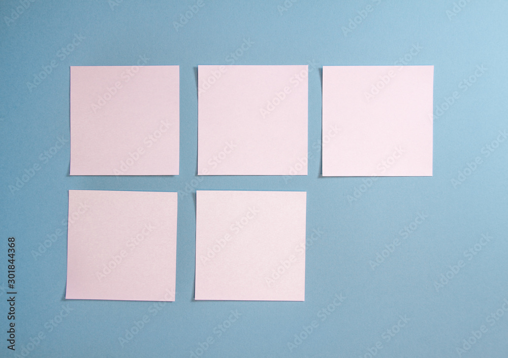 5 blank empty white sticky notes on clean blue background with free space, from top view with copy space 5 blank empty white sticky notes on clean blue background with free space, from top view with copy space