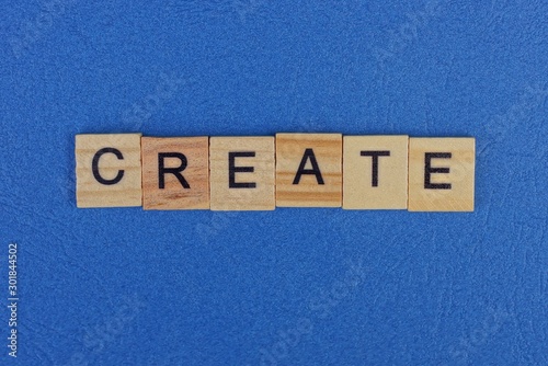 word create from brown wooden letters lies on a blue table