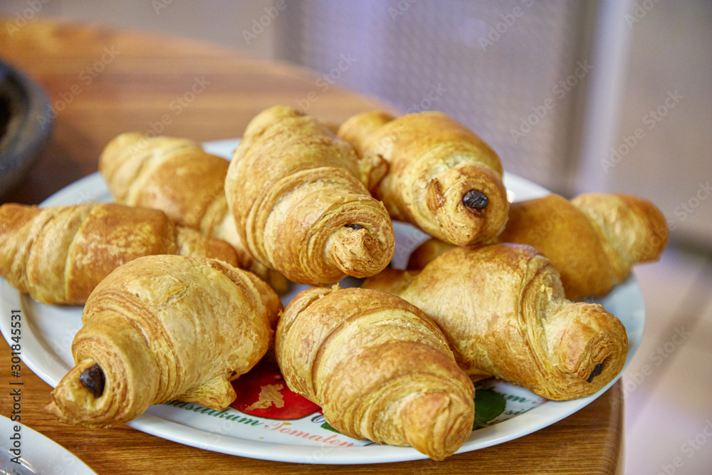 Chocolate croissants sprinkled with powdered sugar lie on a plate