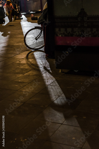 Sombra de una bicicleta proyectada por el alumbrado de la calle