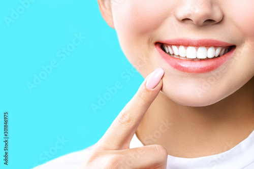 Perfect healthy teeth smile of a young woman. Teeth whitening. Dental clinic patient. Image symbolizes oral care dentistry, stomatology. blue Background photo