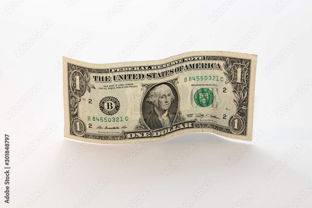 One Dollar bill, lightly used and standing on its side on a white background