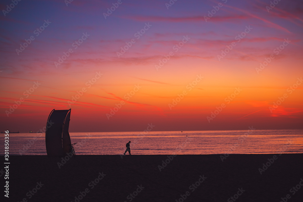 Sea sunrise and Varna beach, Bulgaria. Man walking on the sand in the morning