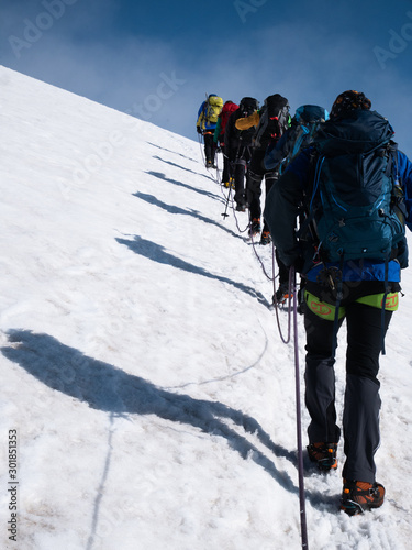 Canvas-taulu a group of alpinists is hiking as a roped party on a glacier