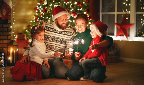 happy family mother, father and children celebrate Christmas and new year, light sparklers.