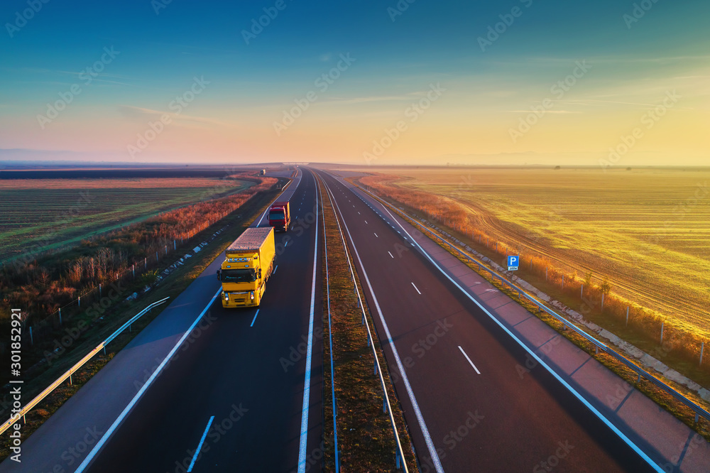 Aerial view of highway on sunset. Transportation background. Landscape with road near countryside fields - obrazy, fototapety, plakaty 