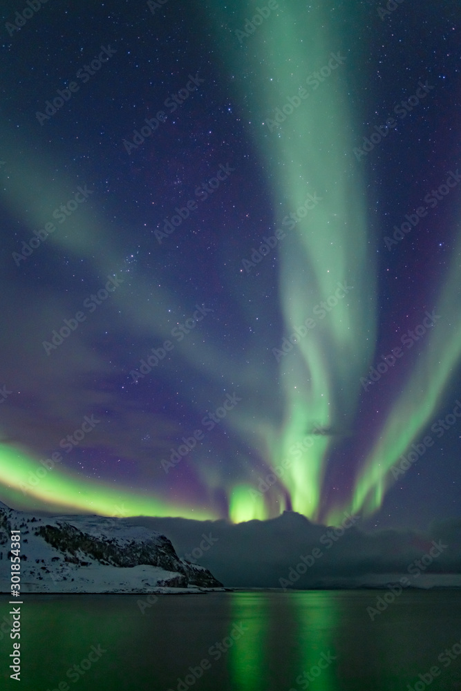 Intense northern lights, Aurora Borealis at a bay near Honningsvag and the Nordkapp, North Cape, Finnmark, Norway