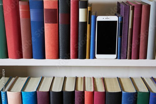 Accurate bookcase with mobile phone standing upright
