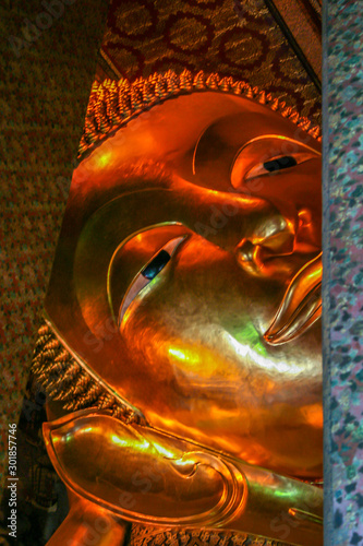 2011.05.14, Bangkok, Thailand. A head of the Golden statue in Wat Pho, front view. Interior of the Temple of the Reclining Buddha. Famous sights of Bangkok.