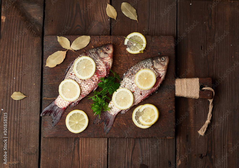 fresh crucian fish sprinkled with spices and lemon slices fresh crucian fish sprinkled with spices and lemon slices