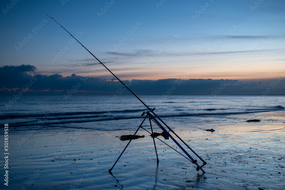 Beautiful sunset at low tide and fishing rod ready for night fishing at low tide in Bognor Regis. Beautiful sunset at low tide and fishing rod ready for night fishing at low tide in Bognor Regis.