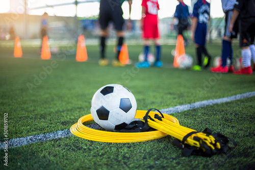 Soccer ball , drills ladder and drills rings on green artificial turf for soccer training equipment.