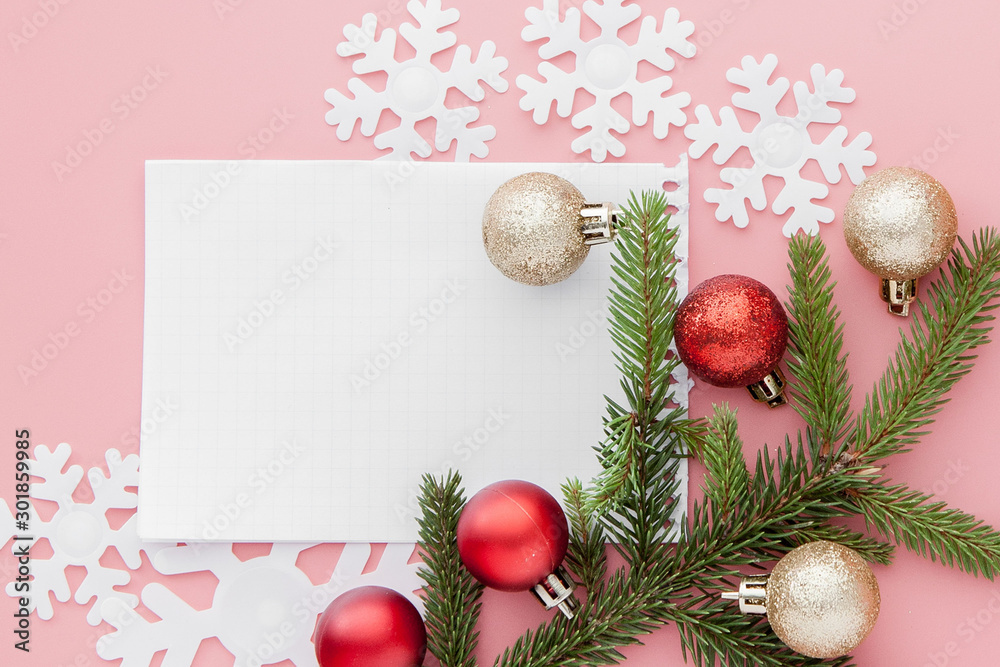 New year concept. Goals list in notepad, gift box and christmas decoration on pink pastel color with copy space
