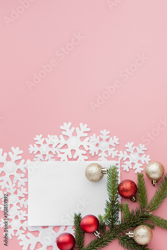 New year concept. Goals list in notepad  gift box and christmas decoration on pink pastel color with copy space