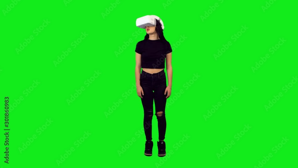 Amazed teenage girl using a VR application or game, full body shot over green screen.