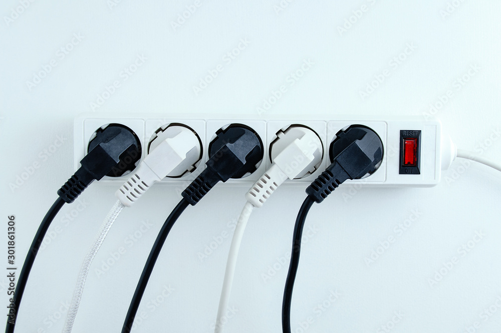 Electric white portable socket with connected devices on a white background. - obrazy, fototapety, plakaty 