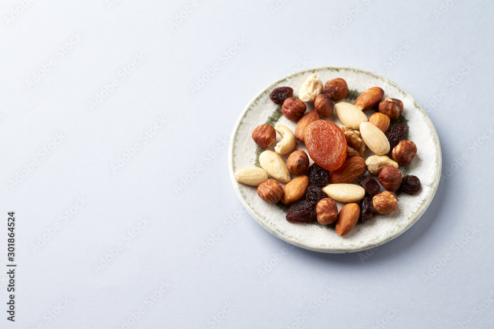 Nuts, raisins and apricots on bright paper background. Concept for healthy snack. Copy space. Nuts, raisins and apricots on bright paper background. Concept for healthy snack. Copy space.