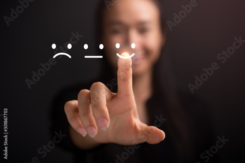 Businesswoman pressing smiley face touch screen . Business Service Satisfaction concept