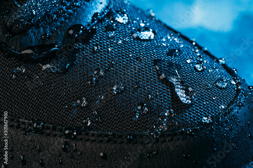 Water drops on waterproof membrane fabric of shoes surface, macro shot. New waterproofing technology for wear and footwear for active lifestyle.