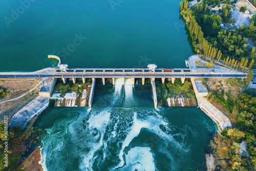 Fotografering Aerial view of Dam at reservoir with flowing water, hydroelectricity power station, drone photo