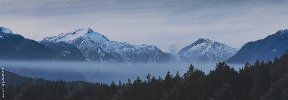 Obraz premium Beautiful scenic landscapes of the pacific north wests Bowen Island BC Canada. With pristine lakes, fog, mist, and rocky beaches with mountain backgrounds.