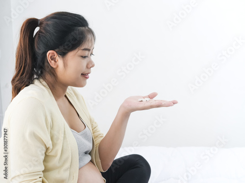 Asian pregnant woman with drugs in her hand, medical and health concept.