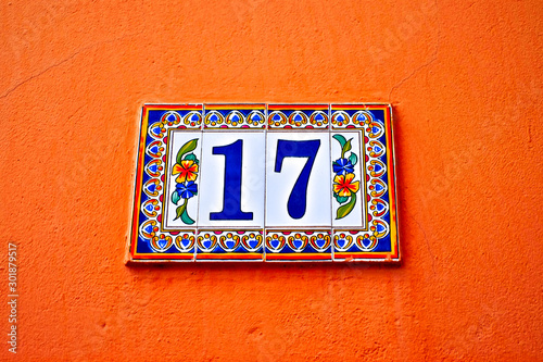 Beautiful floral number 17, seventeen, tiles on orange background.