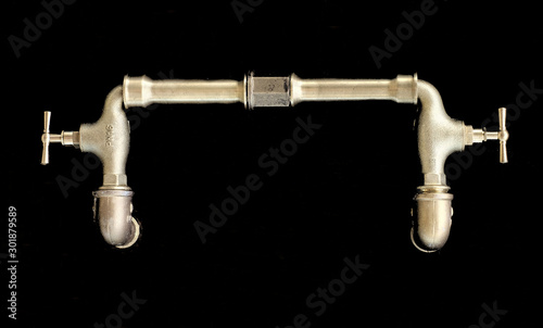 Abstract golden (brass or bronze) water taps isolated on very dark background.