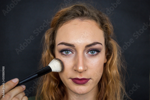 Portrait, beautiful girl, make-up, with smile posing on black background, makeup, powder, eye shadow, mascara, lipstick, eyeshadow