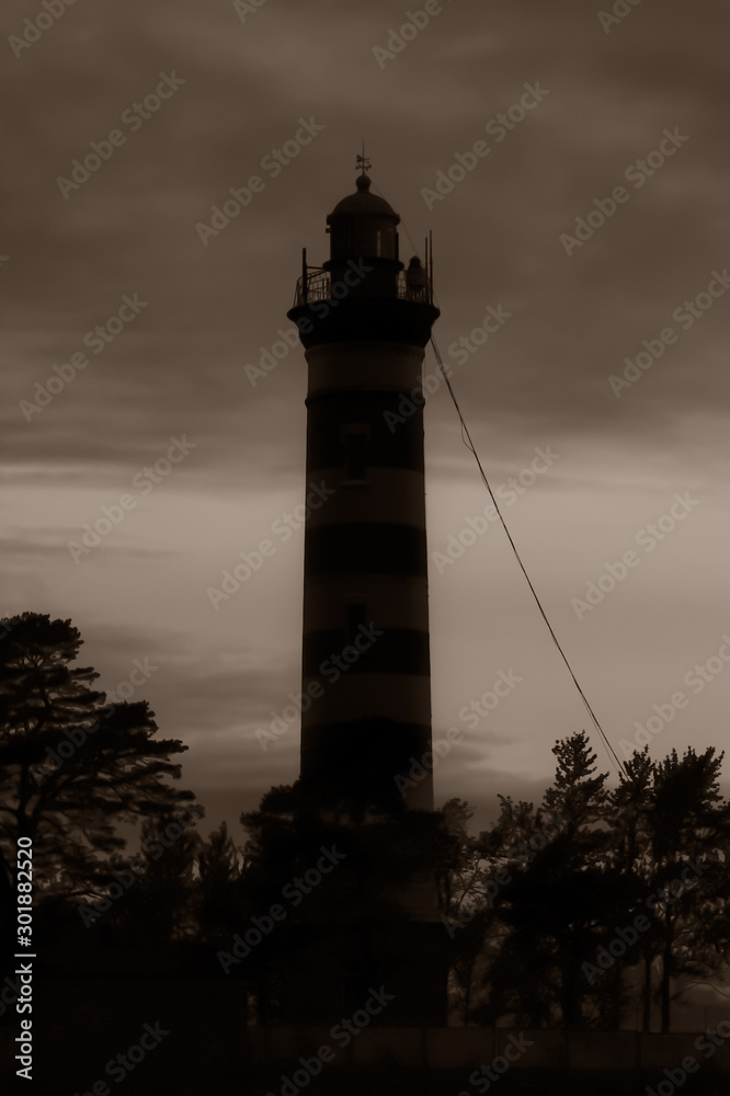 High lighthouse tower silhouette in the dark