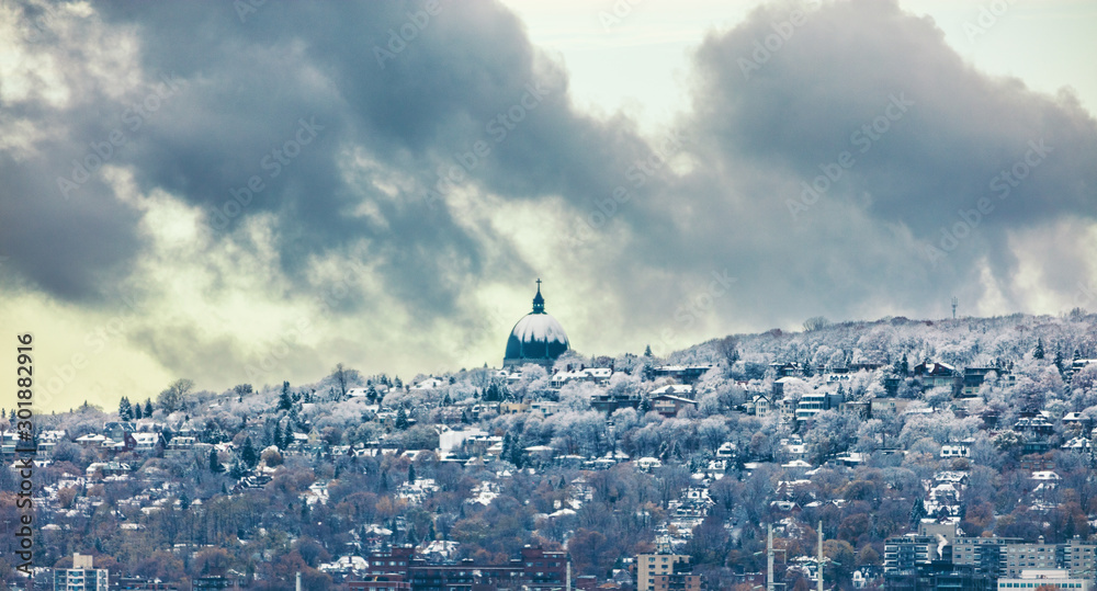 Montreal skyline with first snow falling on Saint Joseph Oratory. Winter view with Mt Royal mount. Quebec Canada city travel North America destination. november 2019.