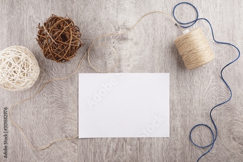 twine and two decorative balls, burlap and coffee mug on light gray wooden background. Space for text