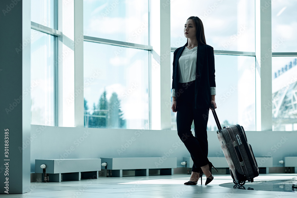 Young asian business woman in airport with baggage trolley bag, waiting for departure Young asian business woman in airport with baggage trolley bag, waiting for departure