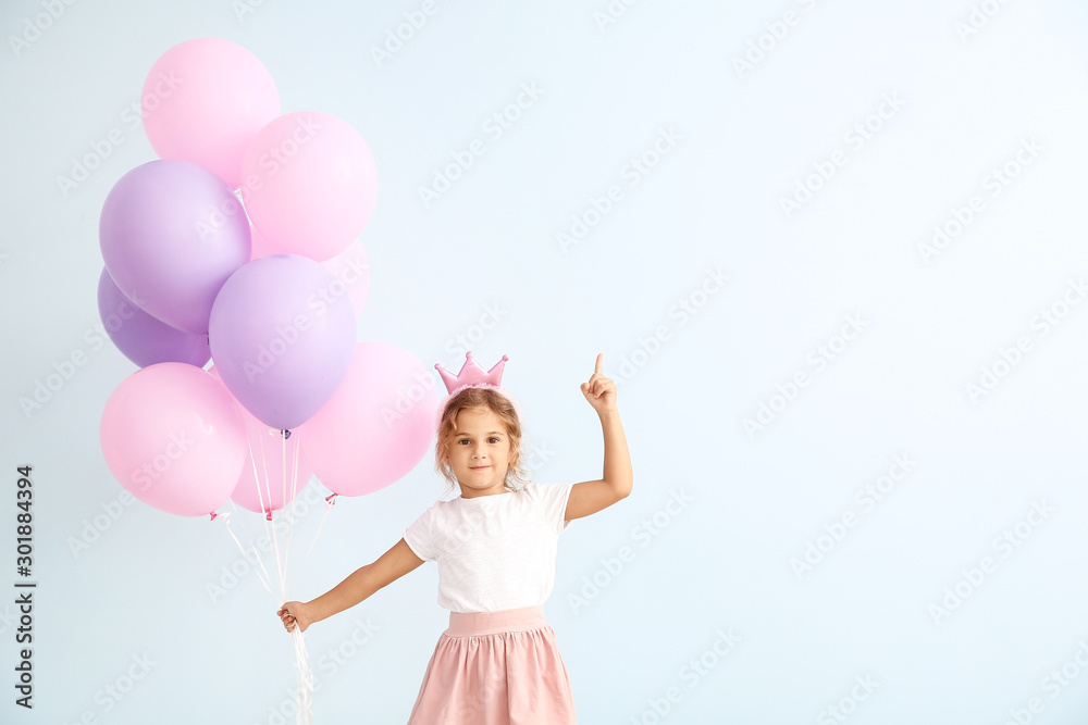 Little girl with balloons and raised index finger on color background Little girl with balloons and raised index finger on color background