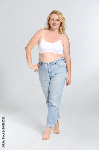 Mature body positive woman on grey background © Pixel-Shot
