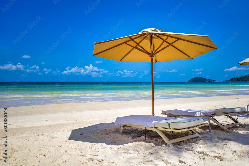 Sandy beach on the bay, sun loungers for relaxation and sunbathing under umbrellas, Phu Quoc island, Vietnam