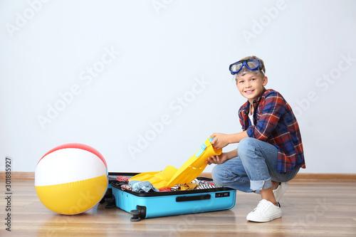 Cute little boy packing sui...