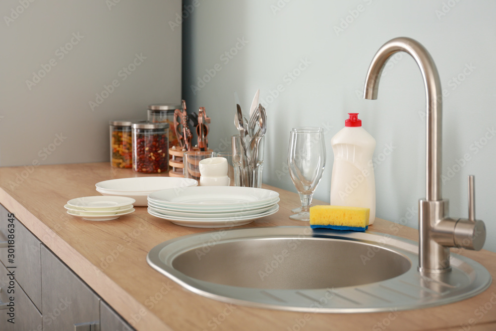 Fototapeta premium Set of clean dishware near kitchen sink